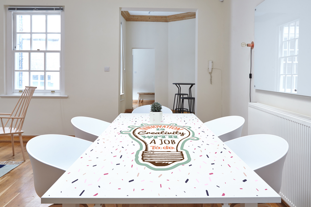 Adhésif pvc blanc personnalisé appliqué professionnellement sur une surface plane en bois, démontrant une adhérence sans bulles et une découpe précise. La finition blanc opaque brillant démontre la qualité supérieure de Sprint24 pour les impressions grand format personnalisées sur surfaces plates. Idéal pour créer des graphiques de marque, stickers sol et applications adhésives contournées avec u…