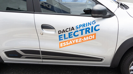 Autocollant commercial professionnel sur Dacia Spring blanche message promotionnel personnalise. Sprint24.