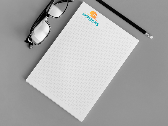 Block notes A4 personnalise template quadrille logo Horizons lunettes et crayon sur bureau gris. Sprint24.