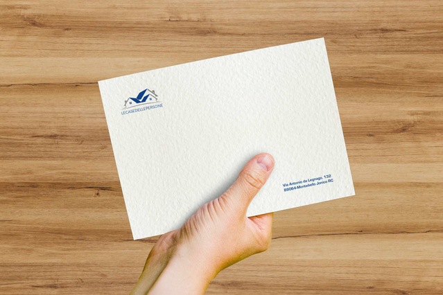 Enveloppe Tintoretto Neve papier martele sur bureau bois Enveloppe Tintoretto Neve effet neige FSC avec logo. Evenements prestige et mariage Sprint24.