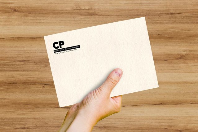 Une enveloppe Freelife Vellum White en papier style parchemin légèrement vieilli, avec logo 'CP' et adresse imprimés, tenue sur une surface en bois. Sprint24 imprime des enveloppes Vellum White sur papier recyclé certifié FSC composé de pure cellulose et coton — idéales pour marques éco-responsables, invitations raffinées et papeterie corporate au toucher velouté.
