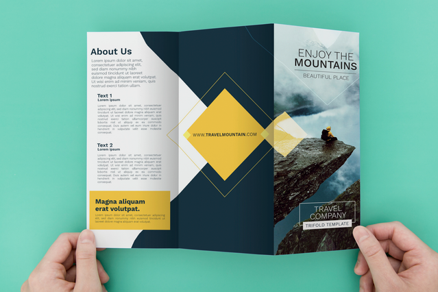 Mains tenant depliant 3 volets Travel Company Enjoy the Mountains. Mains tenant depliant triptyque Travel Company Enjoy the Mountains photo alpiniste et accents dores. Sprint24.