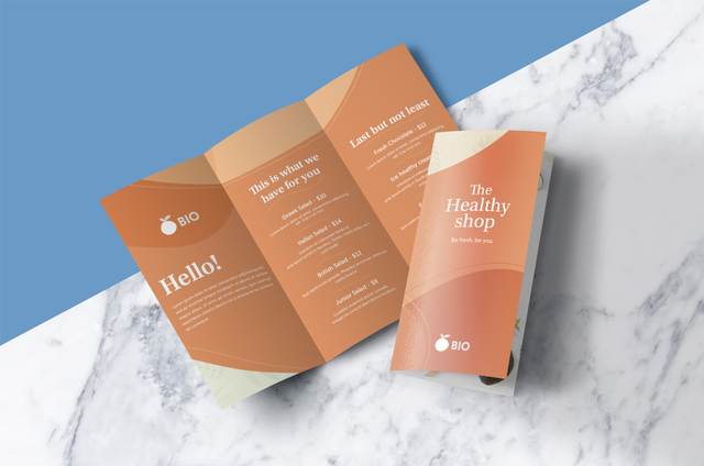 Maquette imprimée brochure pliante orange design Brochure tri-volets premium orange pour salons de beaute et marques wellness. Sprint24.