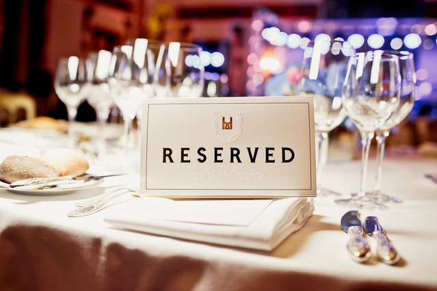 Marque-place blanc réservé avec couronne pour restaurants. Typographie élégante pour table formelle.