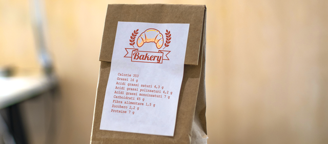 Étiquette papier blanche design boulangerie sur sac kraft. Sticker avec info produit pour emballage alimentaire et artisans.